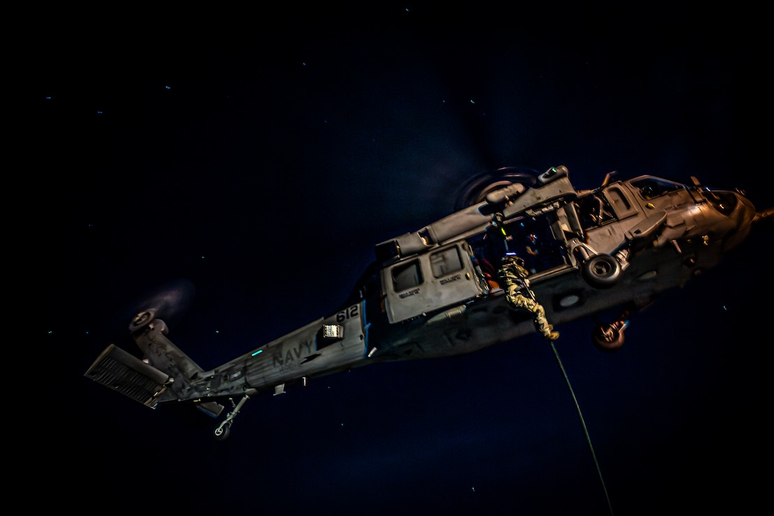 Members of Explosive Ordnance Disposal Mobile Unit 11 fast-rope out of an MH-60S Sea Hawk helicopter from the “Indians” of Helicopter Sea Combat Squadron (HSC) 6 onto the flight deck of the aircraft carrier USS Nimitz (CVN 68) in the South China Sea, May 11, 2025. The Nimitz is underway in the U.S. 7th Fleet area of operations on a scheduled deployment, demonstrating the U.S. Navy's unwavering commitment to a free and open Indo-Pacific. (U.S. Navy photo by Mass Communication Specialist 2nd Class Hannah Kantner)