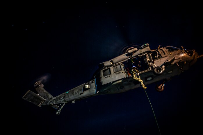 Members of Explosive Ordnance Disposal Mobile Unit 11 fast-rope out of an MH-60S Sea Hawk helicopter from the “Indians” of Helicopter Sea Combat Squadron (HSC) 6 onto the flight deck of the aircraft carrier USS Nimitz (CVN 68) in the South China Sea, May 11, 2025. The Nimitz is underway in the U.S. 7th Fleet area of operations on a scheduled deployment, demonstrating the U.S. Navy's unwavering commitment to a free and open Indo-Pacific. (U.S. Navy photo by Mass Communication Specialist 2nd Class Hannah Kantner)