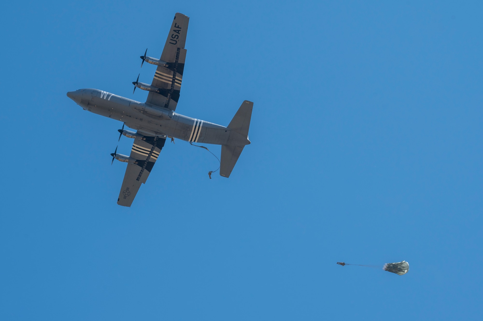 Three U.S. Airmen with the 435th Contingency Response Group perform a static line jump from a U.S. Air Force C-130J Super Hercules at the Megara Drop Zone, Greece, May 3, 2025, during exercise Stolen Cerberus XII.