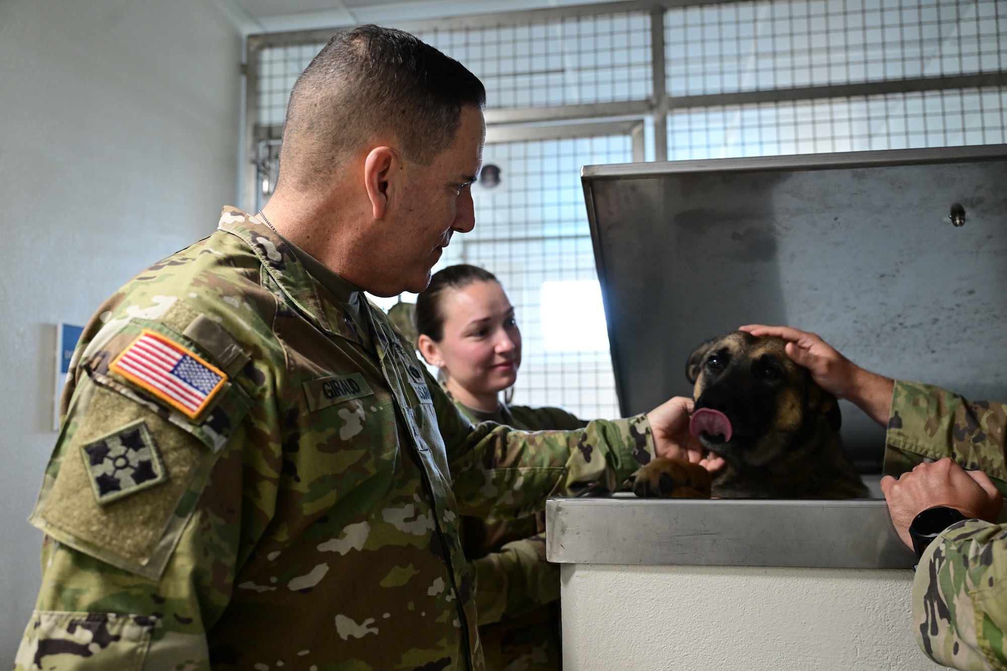 Army soldier pets dog.