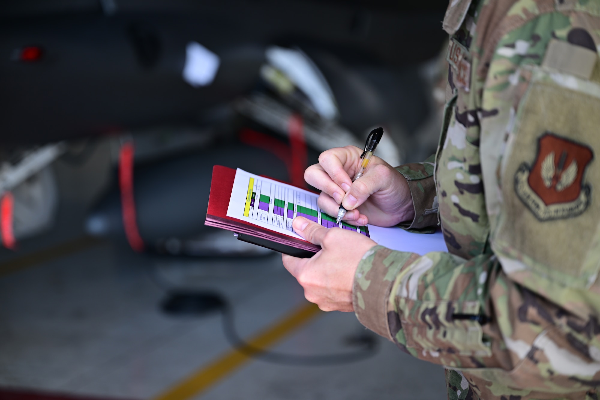 Man takes notes on a clipboard.