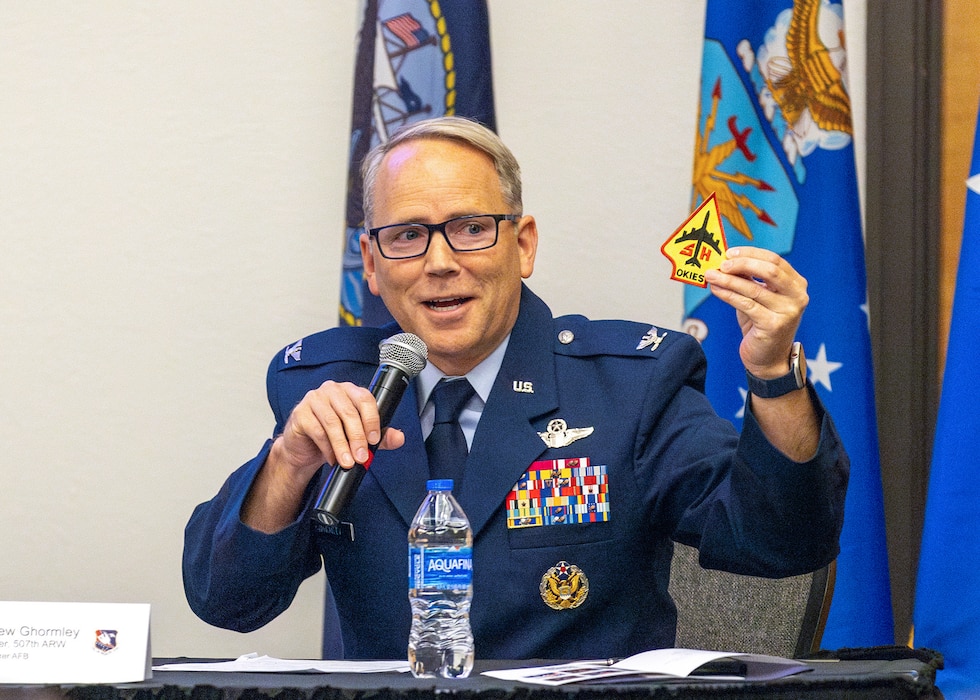 man in military uniform holds microphone