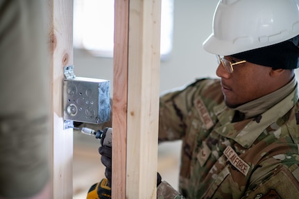 Airman 1st Class Christian McFarland, 138th Civil Engineer Squadron, installs an electrical box during a deployment for training at the Seward Military Resort boathouse in Seward, Alaska, April 14, 2025. The DFT consisted of several construction aspects, including building walls, laying concrete, installing electrical work and plumbing. (Oklahoma Air National Guard Photo by Master Sgt. Rebecca Imwalle)