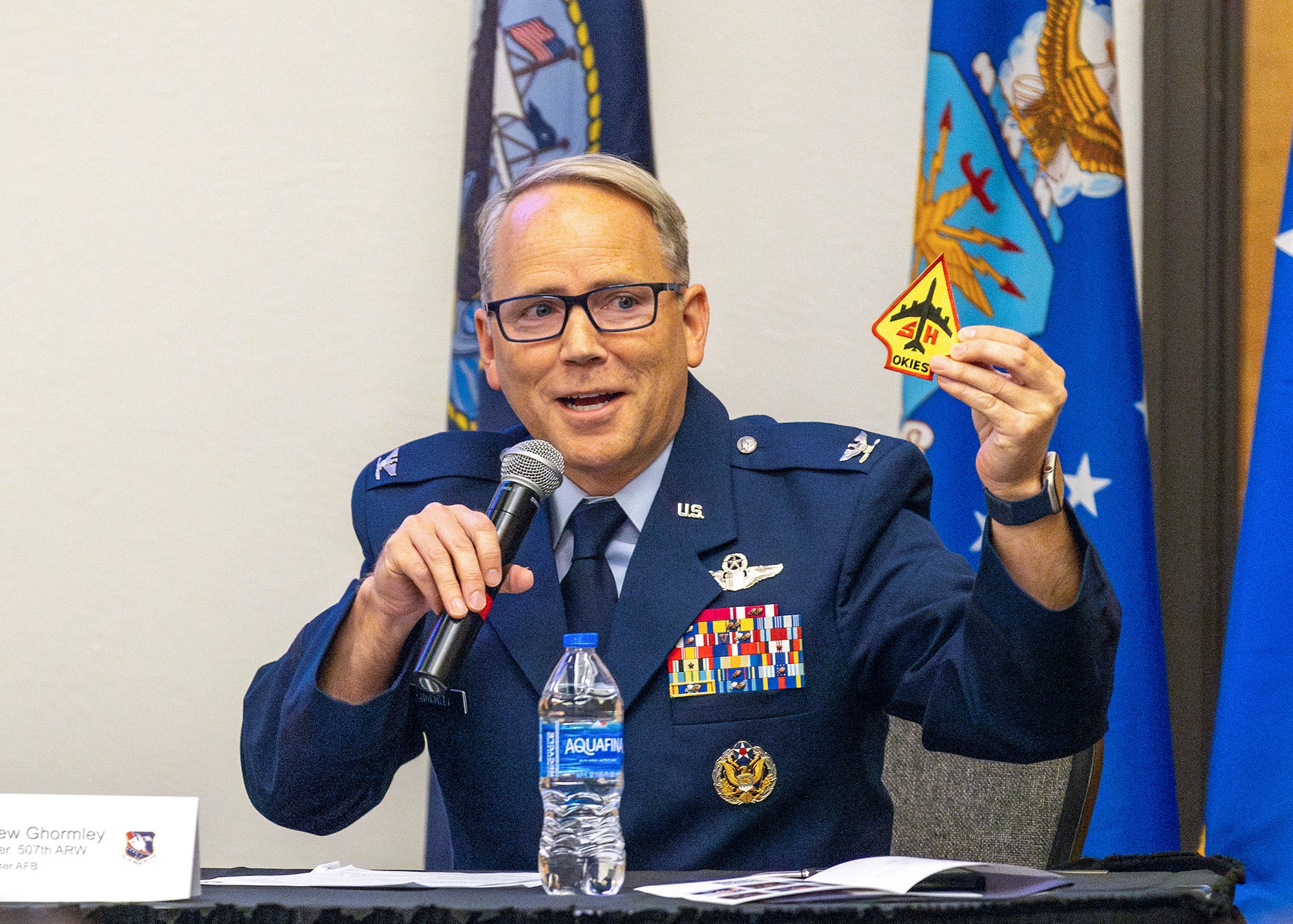 man in military uniform holds microphone
