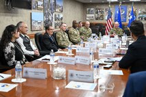 A group of military leadership and Airmen and civilians sitting around a conference table