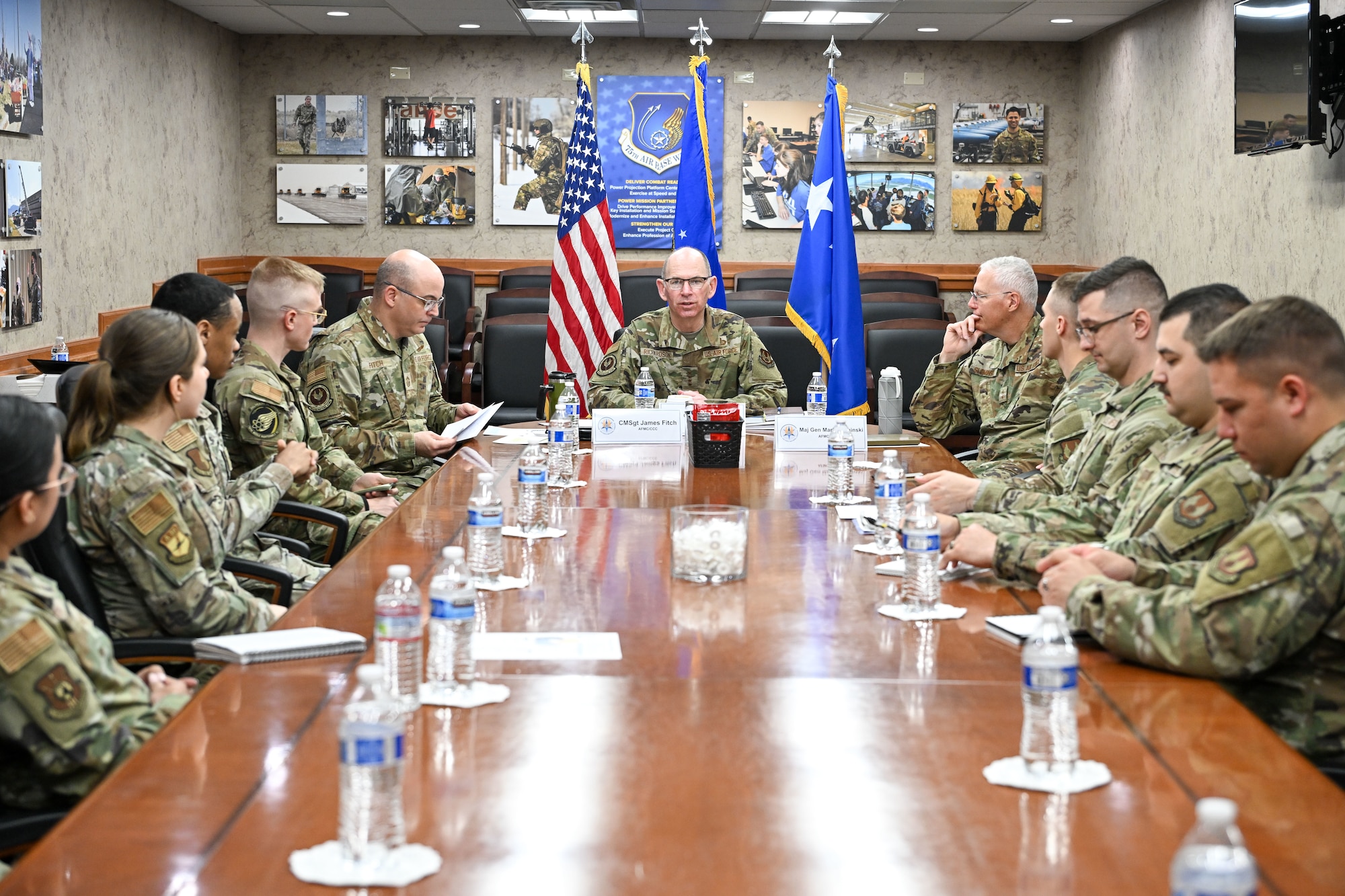 A group of military leadership and Airmen and civilians sitting around a conference table