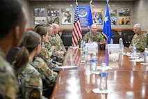 A group of military leadership and Airmen and civilians sitting around a conference table