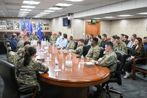 A group of military leadership and Airmen and civilians sitting around a conference table