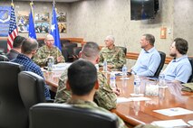 A group of military leadership and Airmen and civilians sitting around a conference table