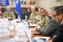 A group of military and civilians around a conference table