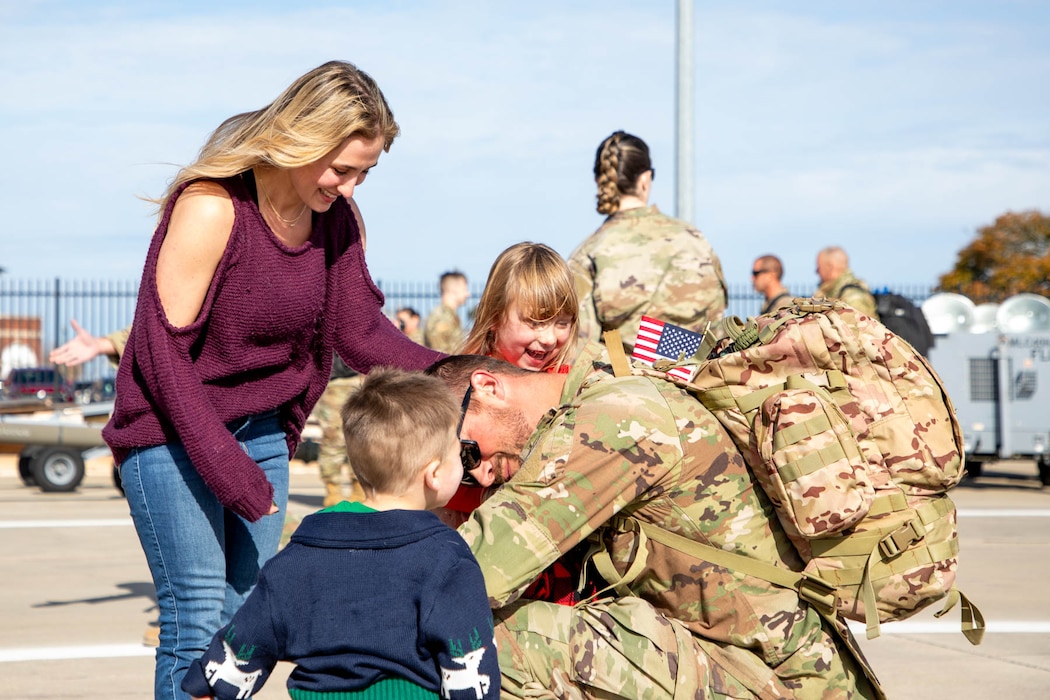 Uniformed members shaking hands and hugging loved ones.