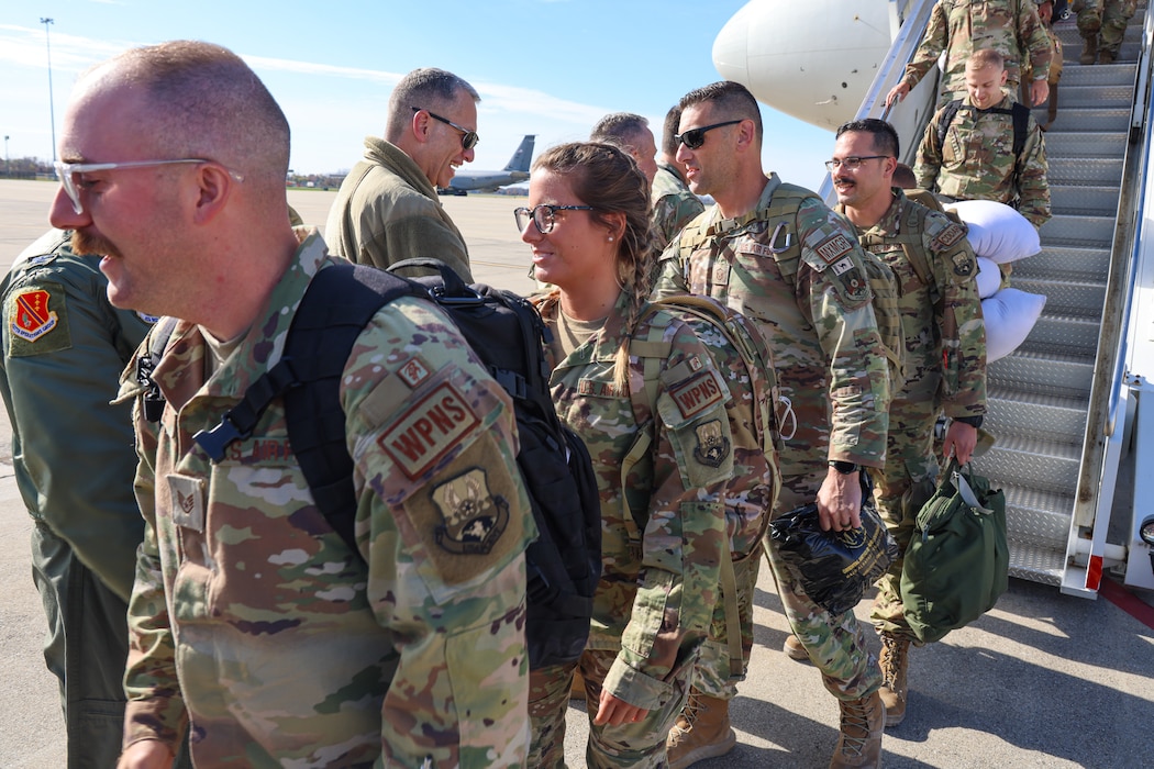 Uniformed members shaking hands and hugging loved ones.