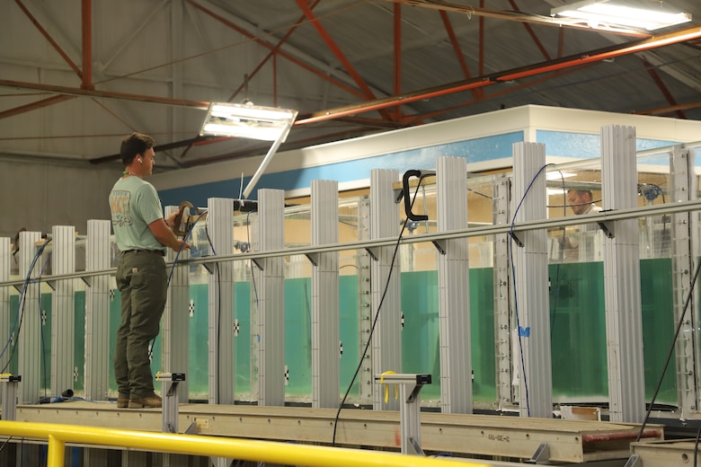Researchers at the U.S. Army Engineer Research and Development Center position sensors in a flume mounted on top of a tilt table.