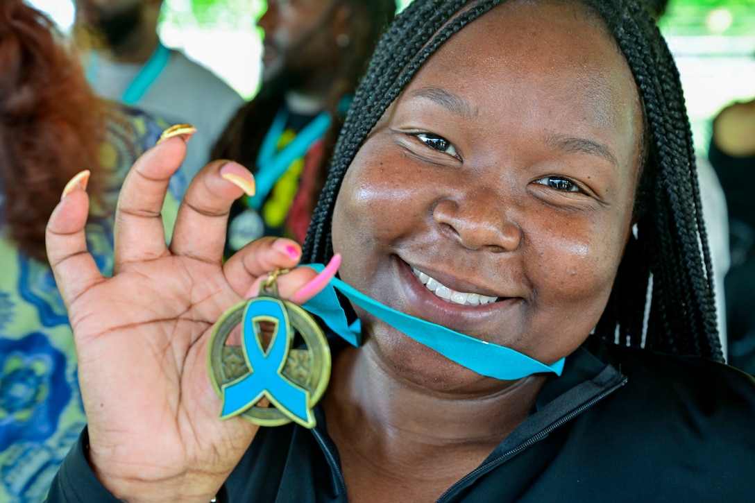 Person holds up a medal