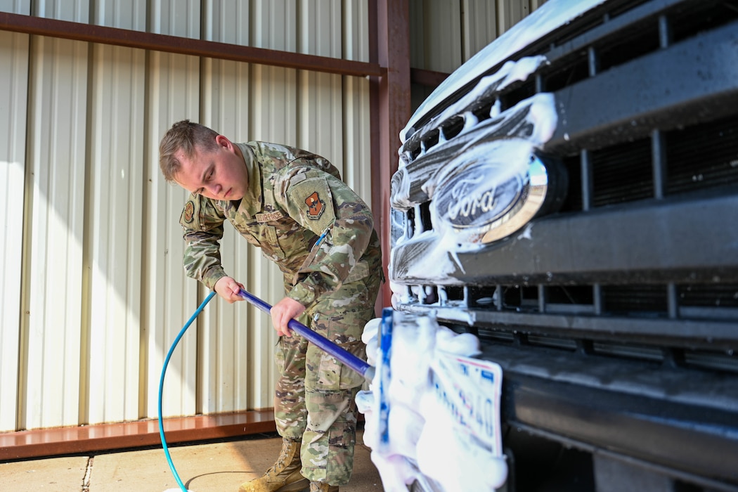 U.S. Air Force Airman 1st Class Ashton Trumps, 97th Logistics Readiness Squadron ground transportation operator, scrubs the front of a government-owned vehicle at Altus Air Force Base, Oklahoma, May 8, 2025. The 97th Air Mobility Wing’s vehicles are used for a variety of reasons, including lending to distinguished visitors, providing rides for Airmen and hauling fuel for our aircraft. (U.S. Air Force photo by Airman 1st Class Lauren Torres)