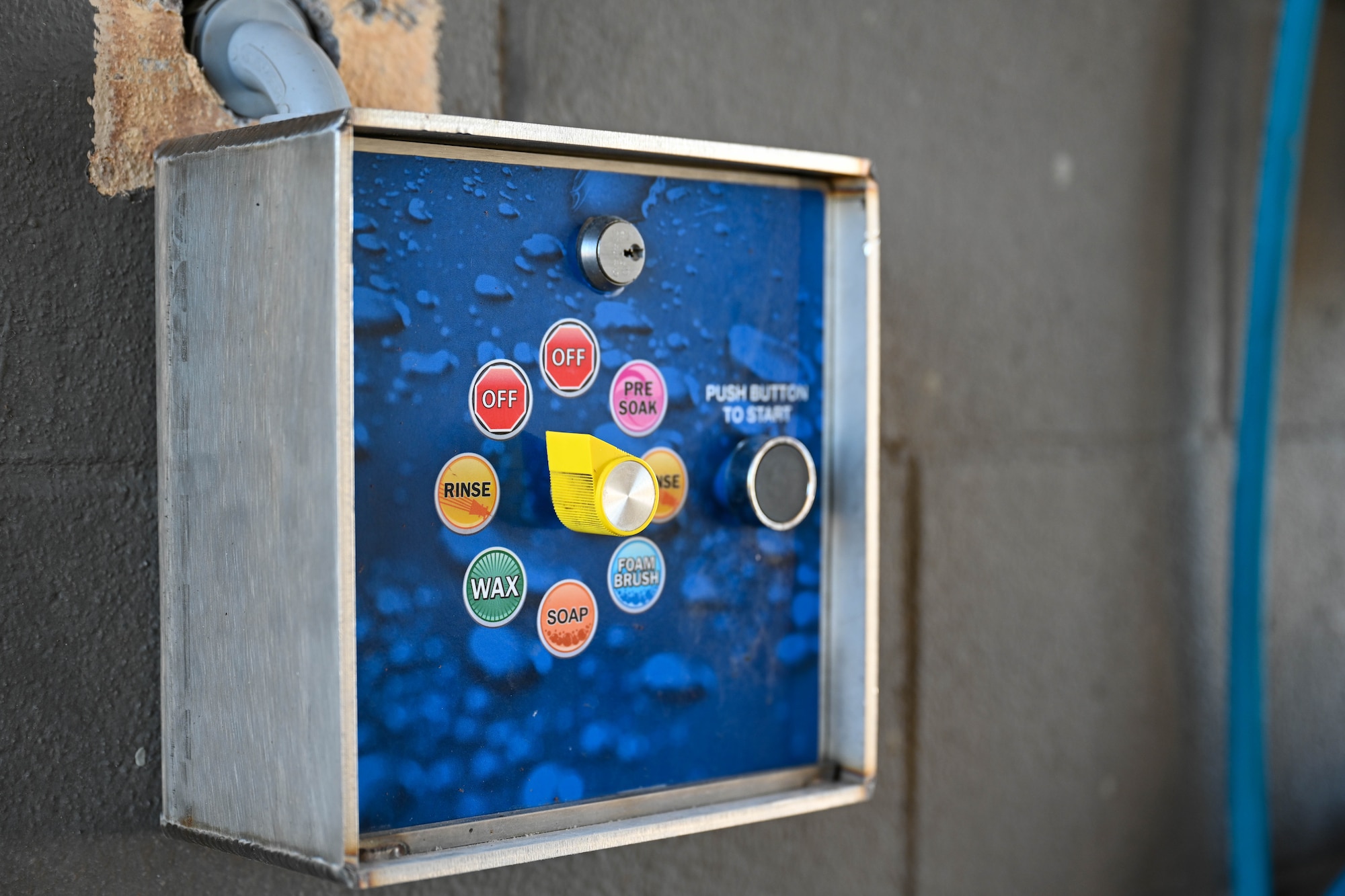 Self service car wash control panel mounted to the wash rack wall at Altus Air Force Base, Oklahoma, May 8, 2025. This car wash panel allows Airmen to select what service they need to wash a government-owned vehicle. (U.S. Air Force photo by Airman 1st Class Lauren Torres)