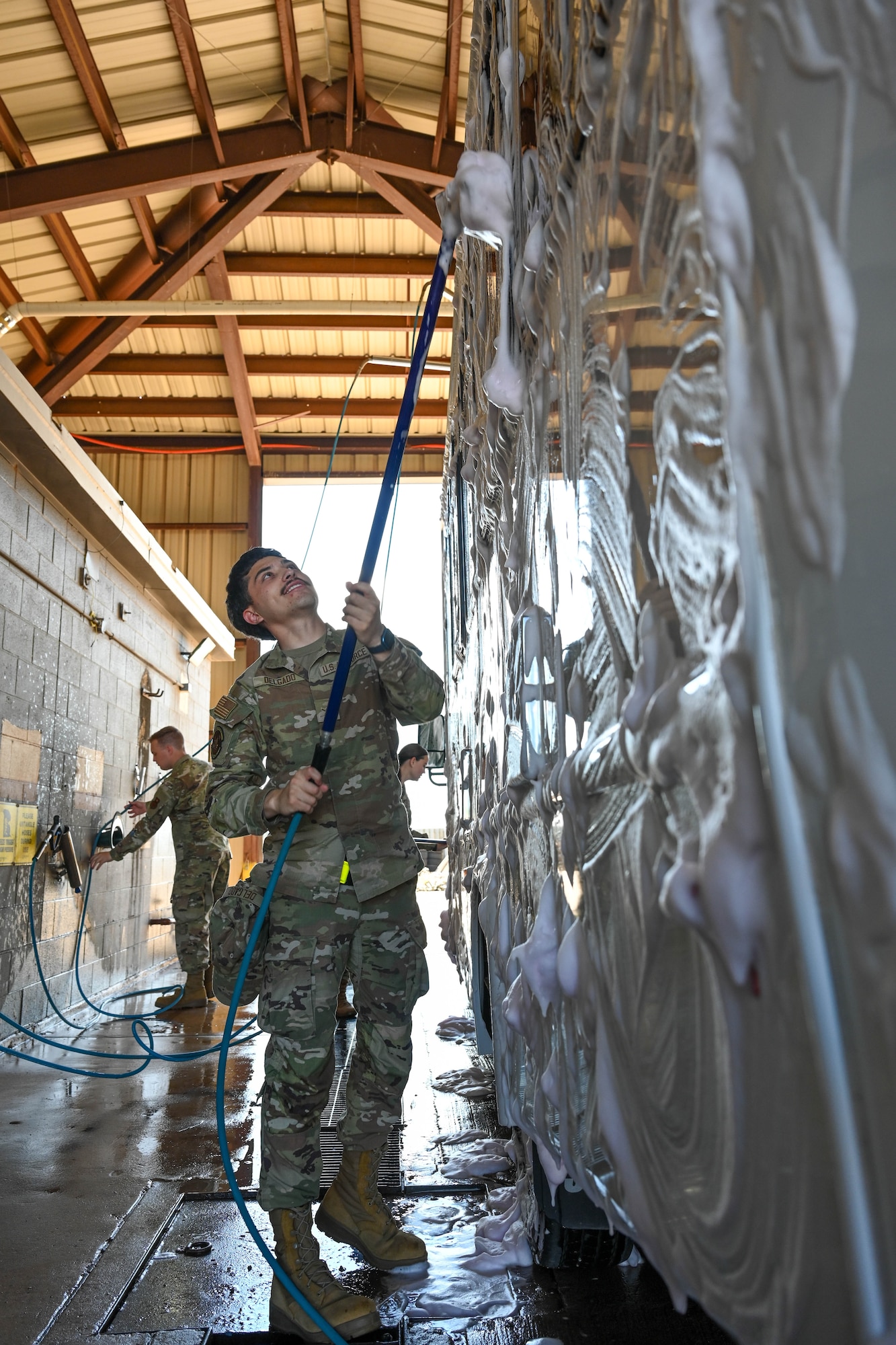 U.S. Air Force Airman Ayden Delgado, 97th Logistics Readiness Squadron ground transportation operator, washes a government-owned vehicle at Altus Air Force Base, Oklahoma, May 8, 2025. The base’s vehicle wash rack, inactive since 2023, recently reopened to support the upkeep and mission readiness of government-owned vehicles. (U.S. Air Force photo by Airman 1st Class Lauren Torres)