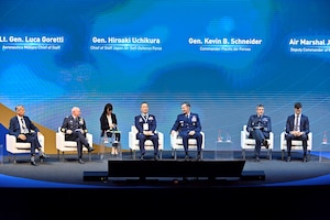 A group of people sit on a stage discussing.