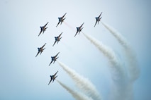 a formation flight of 8 jets turns across the sky