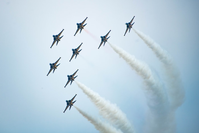 a formation flight of 8 jets turns across the sky