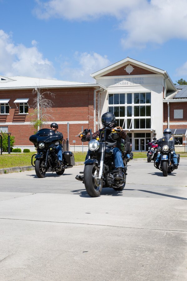 Civilians from the Combat Veteran’s Motorcycle Association arrive at Wallace Creek Fitness Center for the Operation Never Forget flag display on Marine Corps Base Camp Lejeune, North Carolina, May 3, 2025. The flag serves as a powerful tribute to our fallen heroes. Service members are encouraged to sign it and add their unit patches as a symbol of unity, remembrance, and unwavering commitment to honor those who made the ultimate sacrifice. (U.S. Marine Corps photo by Lance Cpl. Devaraja Renshaw)