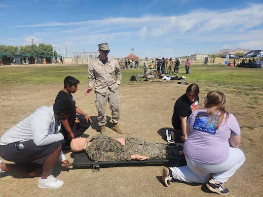 Sailors provide information about Navy Medicine careers to local high school students during a Military Occupational Specialty Exposition held May 1 at Marine Corps Air Ground Combat Center Twentynine Palms. The event used an interactive activity to introduce students to a variety of military career paths and featured hands-on demonstrations highlighting the role of Navy Corpsmen in both clinical and field environments (U.S. Navy courtesy photo).