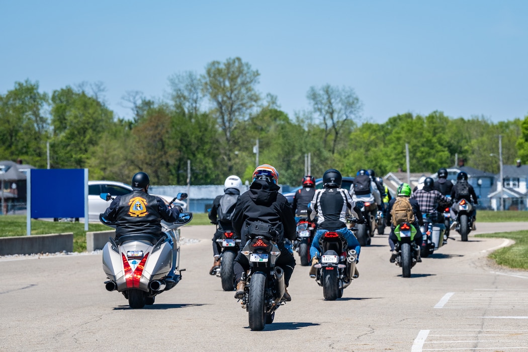 A large group of motorcycles driving away from the viewer POV