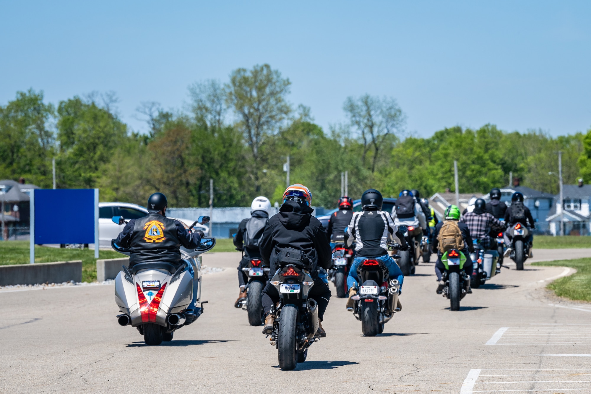 A large group of motorcycles driving away from the viewer POV