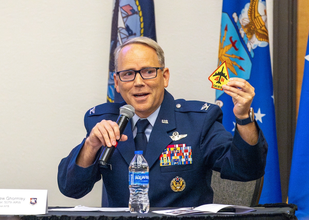 man in military uniform holds microphone