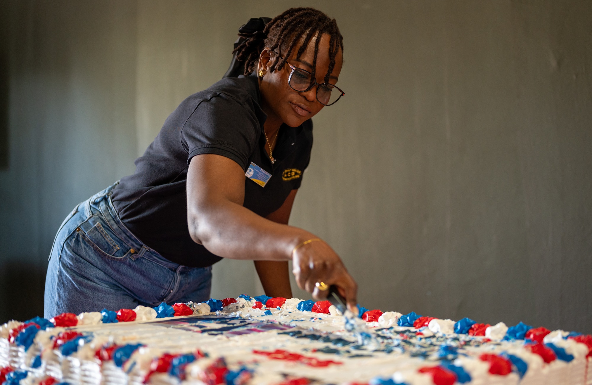 Timi Olusanya, U.S. Army Community Service Family Military Readiness Center volunteer corps coordinator, serves cake to military spouses during the fifth annual Military Spouse Appreciation Day event at Ramstein Air Base, Germany, May 9, 2025. Military Spouse Appreciation Day first began in 1984 to show appreciation for military spouses. (U.S. Air Force photo by Senior Airman Jared Lovett)