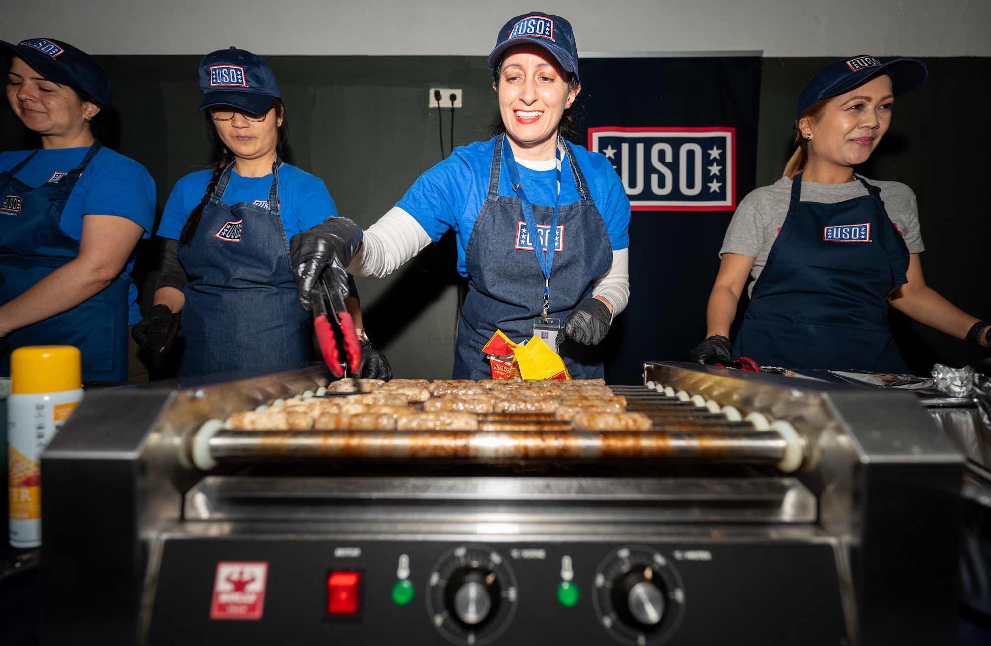 United Service Organizations volunteers serve food to military spouses during the fifth annual Military Spouse Appreciation Day event at Ramstein Air Base, Germany, May 9, 2025. Many Kaiserslautern Military Community supporting agencies participated in the event to show their support for military spouses. (U.S. Air Force photo by Senior Airman Jared Lovett)