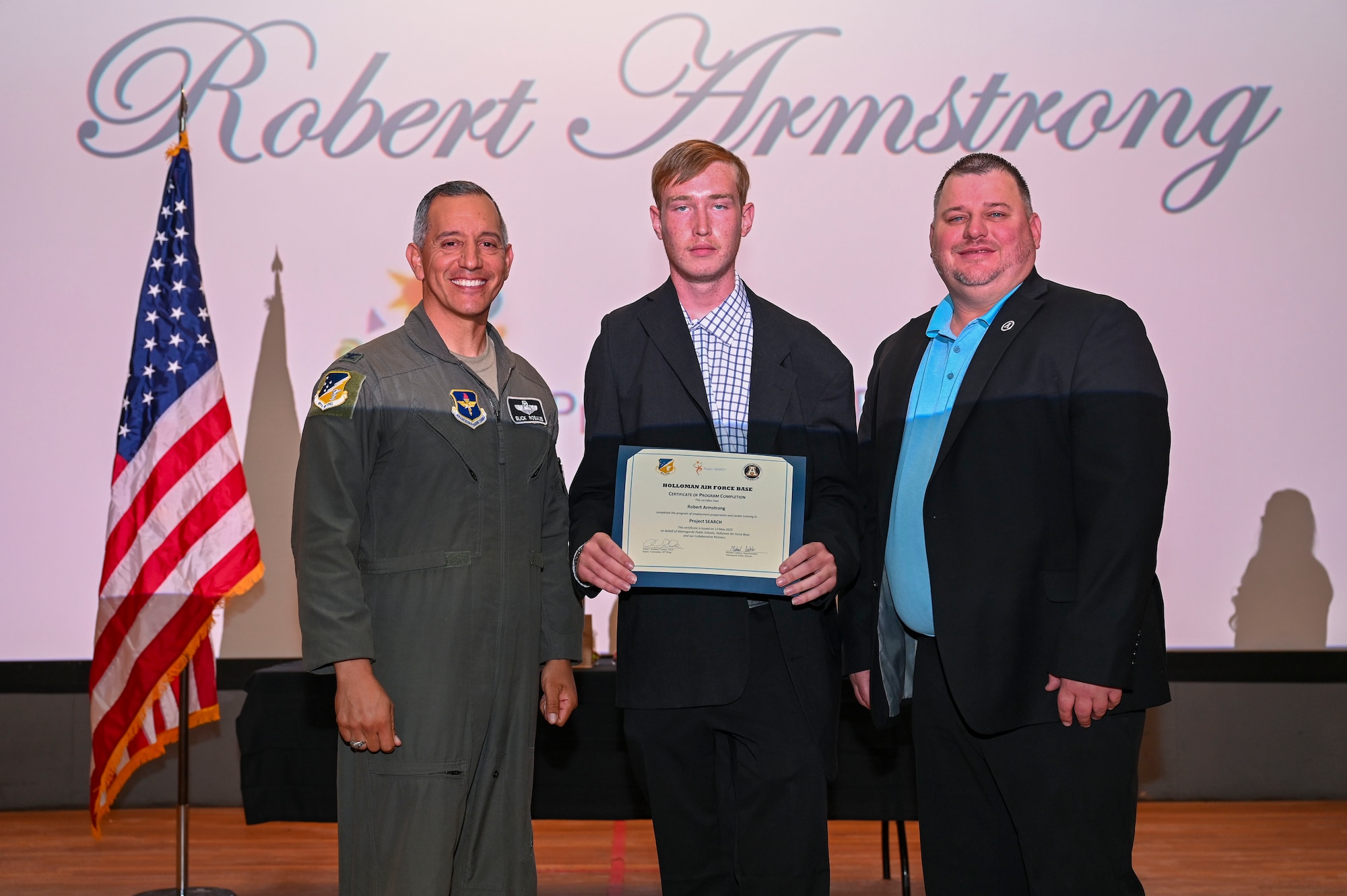 Robert Armstrong, Project SEARCH intern, accepts a graduation certificate at Holloman Air Force Base, New Mexico, May 13, 2025. Project SEARCH integrates 18-22 year olds with disabilities into working environments to help them gain valuable work experience. (U.S. Air Force photo by Senior Airman Michelle Ferrari)