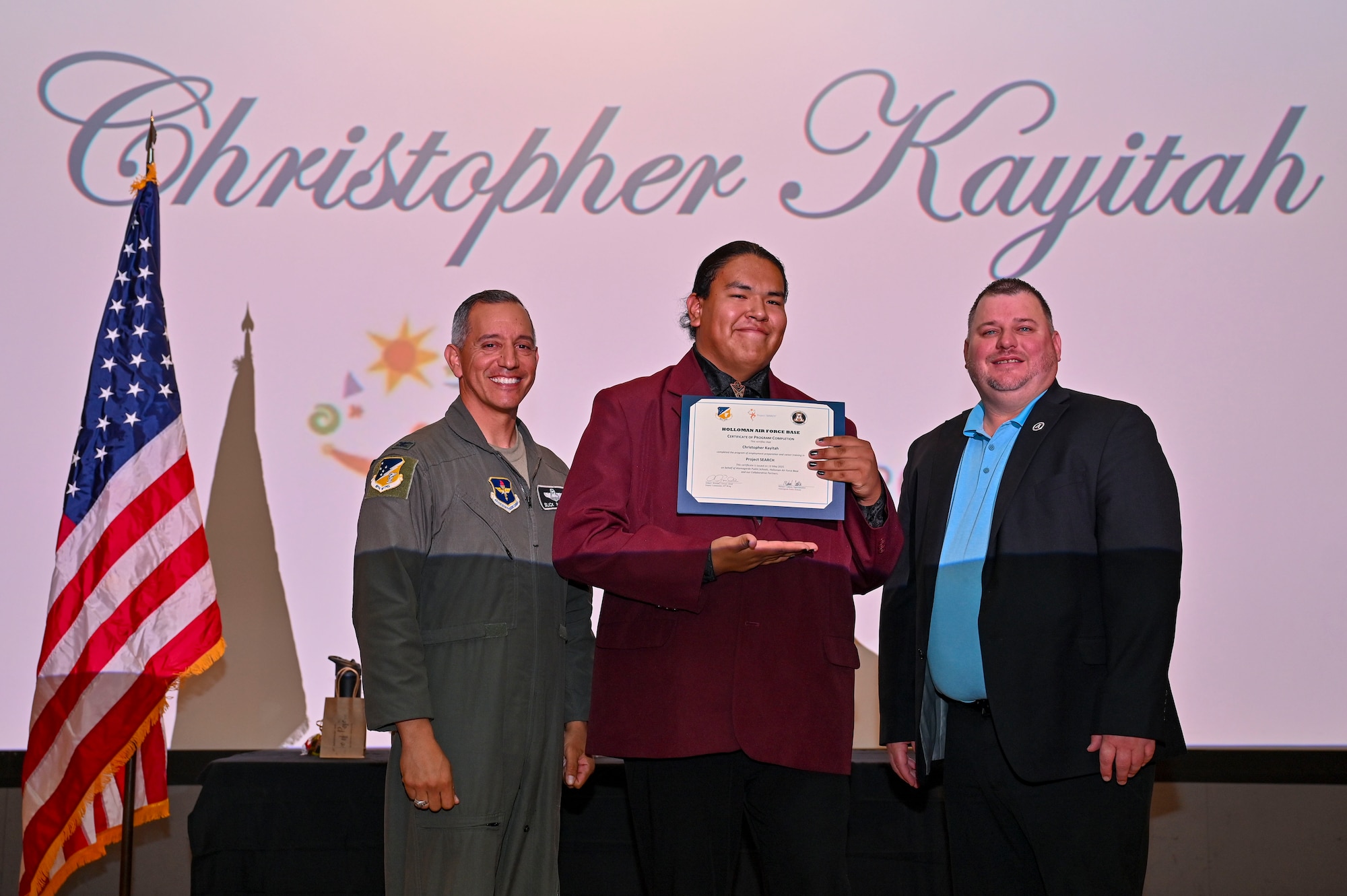 Christopher Kayitah, Project SEARCH intern, accepts a graduation certificate at Holloman Air Force Base, New Mexico, May 13, 2025. Project SEARCH is a high school transition program that provides training and education leading to employment for students with developmental disabilities. (U.S. Air Force photo by Senior Airman Michelle Ferrari)