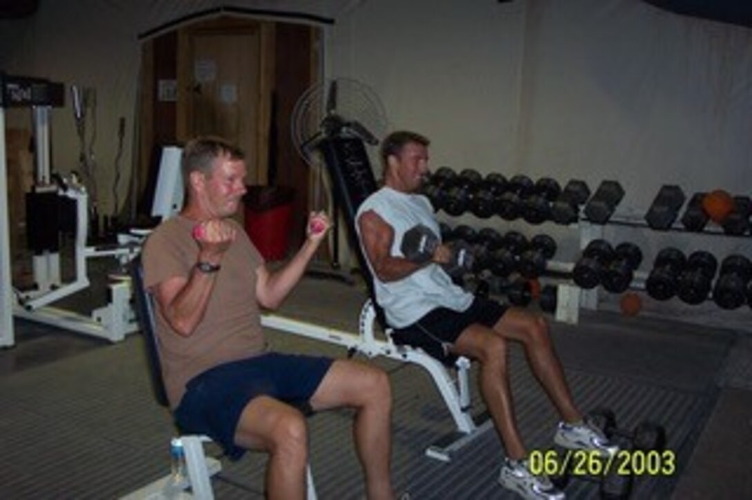 1st Lt CJ Pfeil (right) works out with his father, SMSgt Christopher Pfeil during a Operation Iraqi Freedom in 2003. In between flying sorties, the duo helped build up the base in Saudi Arabia.