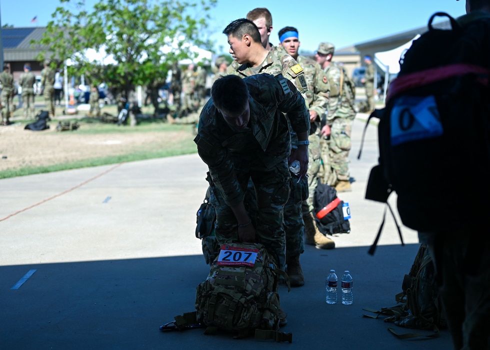 Norwegian Foot March participants wait in line to weigh their rucksacks during the Goodfellow 2025 Norwegian Foot March at the 17th Security Forces Squadron warehouse, Goodfellow Air Force Base, Texas, on May 3, 2025. During the timed 18.6-mile ruck, participants carried a 25-pound rucksack and if they completed it in a given timeframe, depending on their age, they received the official Norwegian Foot March badge. (U.S. Air Force photo by Senior Airman Evelyn J. D’Errico)