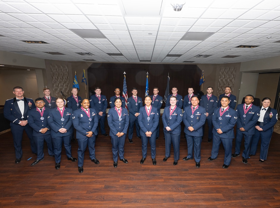 A group of 21 people in uniform stand in formation.