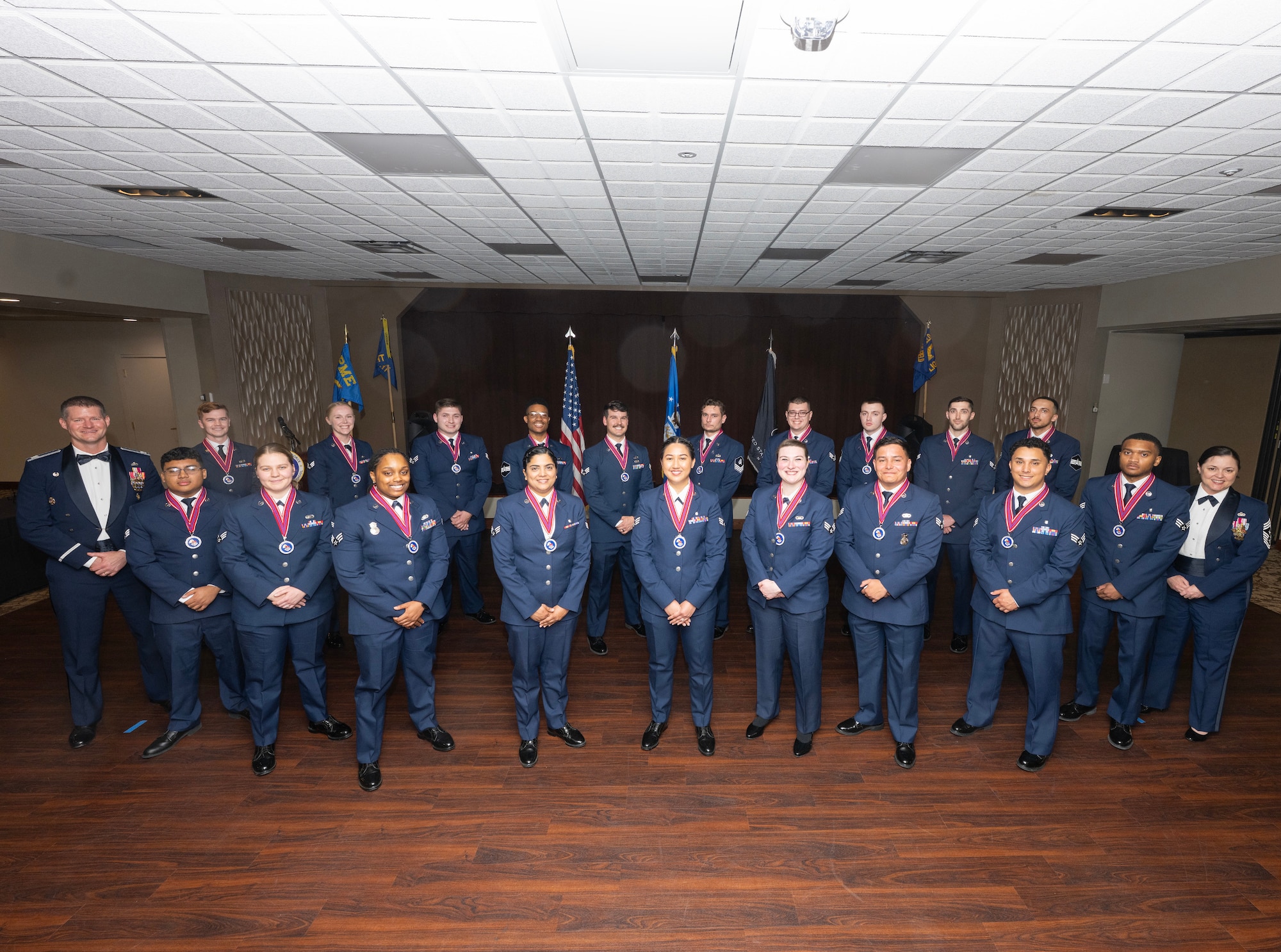A group of 21 people in uniform stand in formation.
