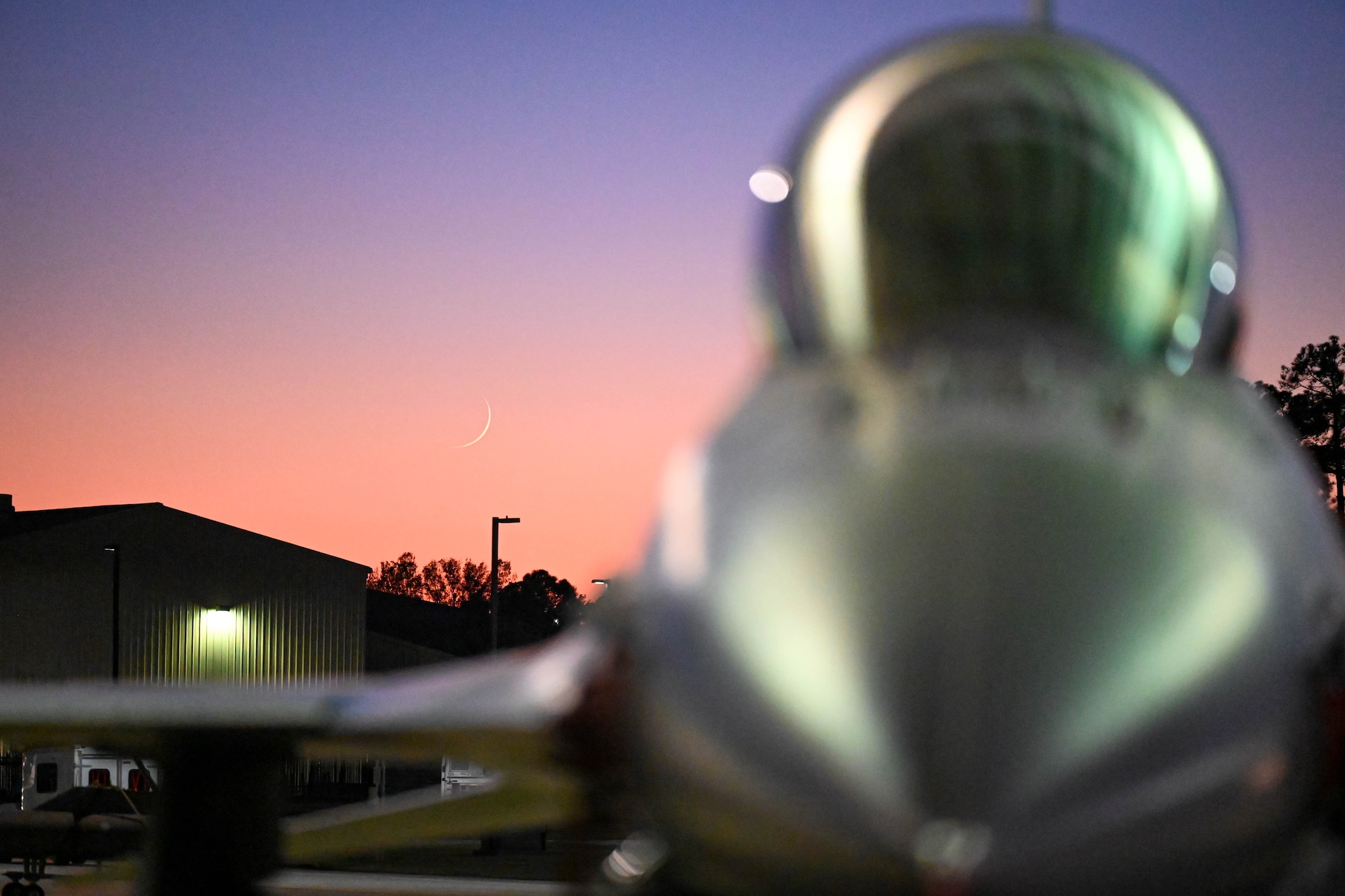 A U.S. Air Force F-16C Fighting Falcon is illuminated by sun shade lights as it gets dark at Shaw Air Force Base, S.C., Dec. 12, 2024. Shaw AFB works constantly to upgrade infrastructure across the installation to increase mission effectiveness and safety. (U.S. Air Force photo by Senior Airman Steven Cardo)