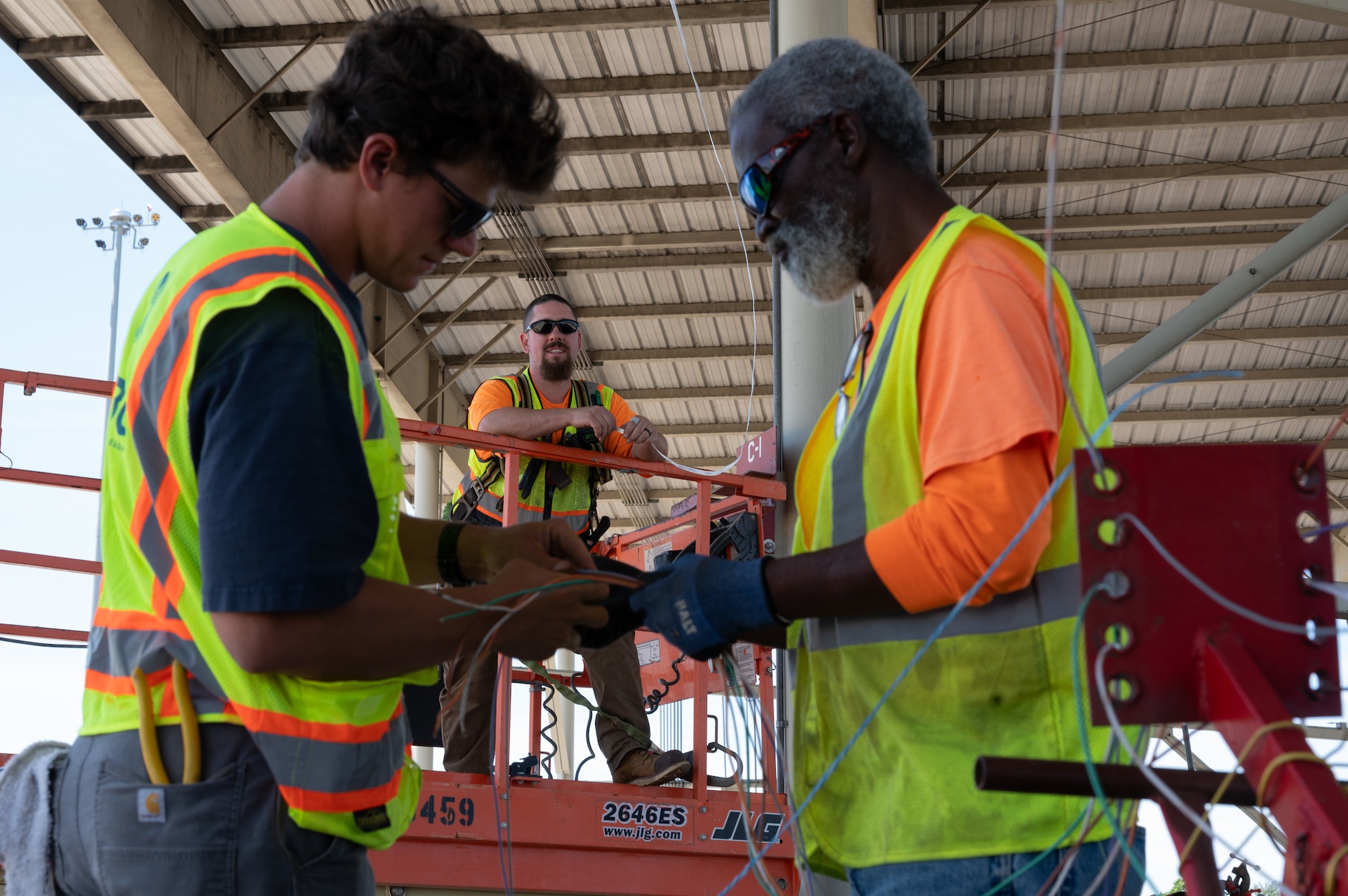 SB Ducom, Mason Eaton and David Walters, contractors supporting the 20th Civil Engineer Squadron, coordinate LED lighting upgrades beneath an aircraft sunshade at Shaw Air Force Base, S.C., May 1, 2025. The work is part of a $1.5 million energy modernization initiative at Shaw Air Force Base, projected to save over $200,000 annually by replacing outdated fixtures with energy-efficient systems. (U.S. Air Force photo by Staff Sgt. Terry Clyburn)