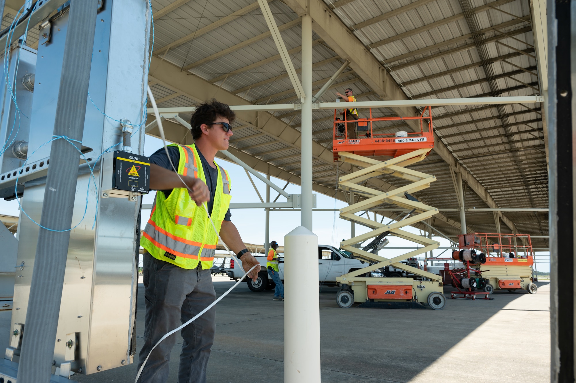 SB Ducom a contractor supporting the 20th Civil Engineer Squadron, installs wiring for new LED fixtures under an aircraft sunshade at Shaw Air Force Base, S.C., May 1, 2025. The effort is part of a base-wide modernization aimed at boosting energy resilience and reducing long-term maintenance demands. (U.S. Air Force photo by Staff Sgt. Terry Clyburn)