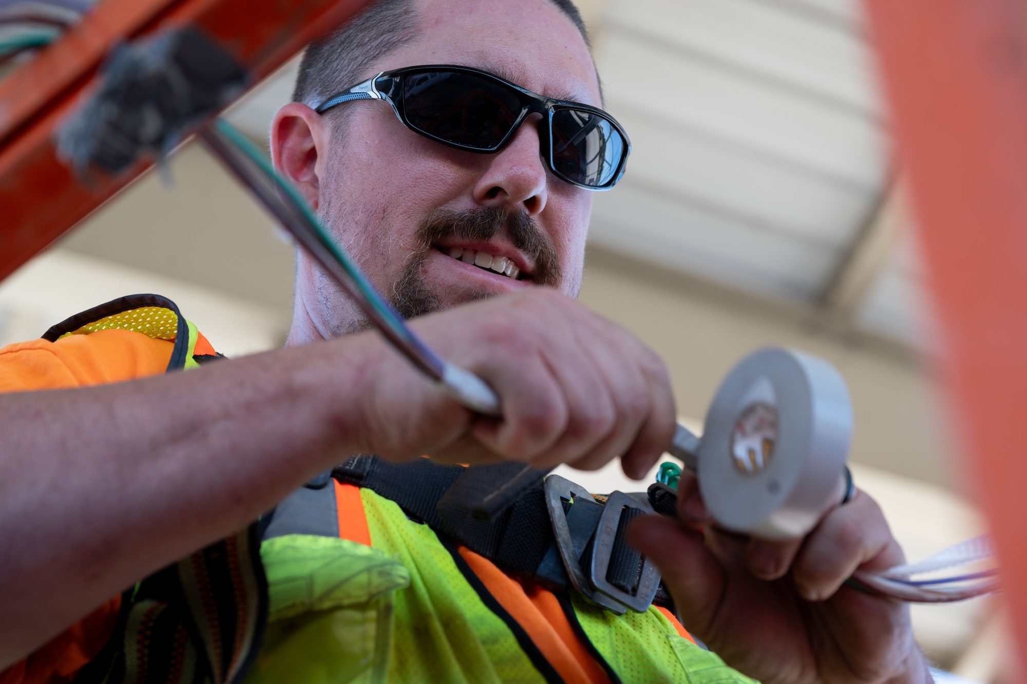 Mason Eaton, a contractor supporting the 20th Civil Engineer Squadron, prepares electrical wiring for LED lighting installation at Shaw Air Force Base, S.C., May 1, 2025. The upgrade supports improved visibility and safety standards across 76 aircraft bays under Shaw’s sunshades. (U.S. Air Force photo by Staff Sgt. Terry Clyburn)