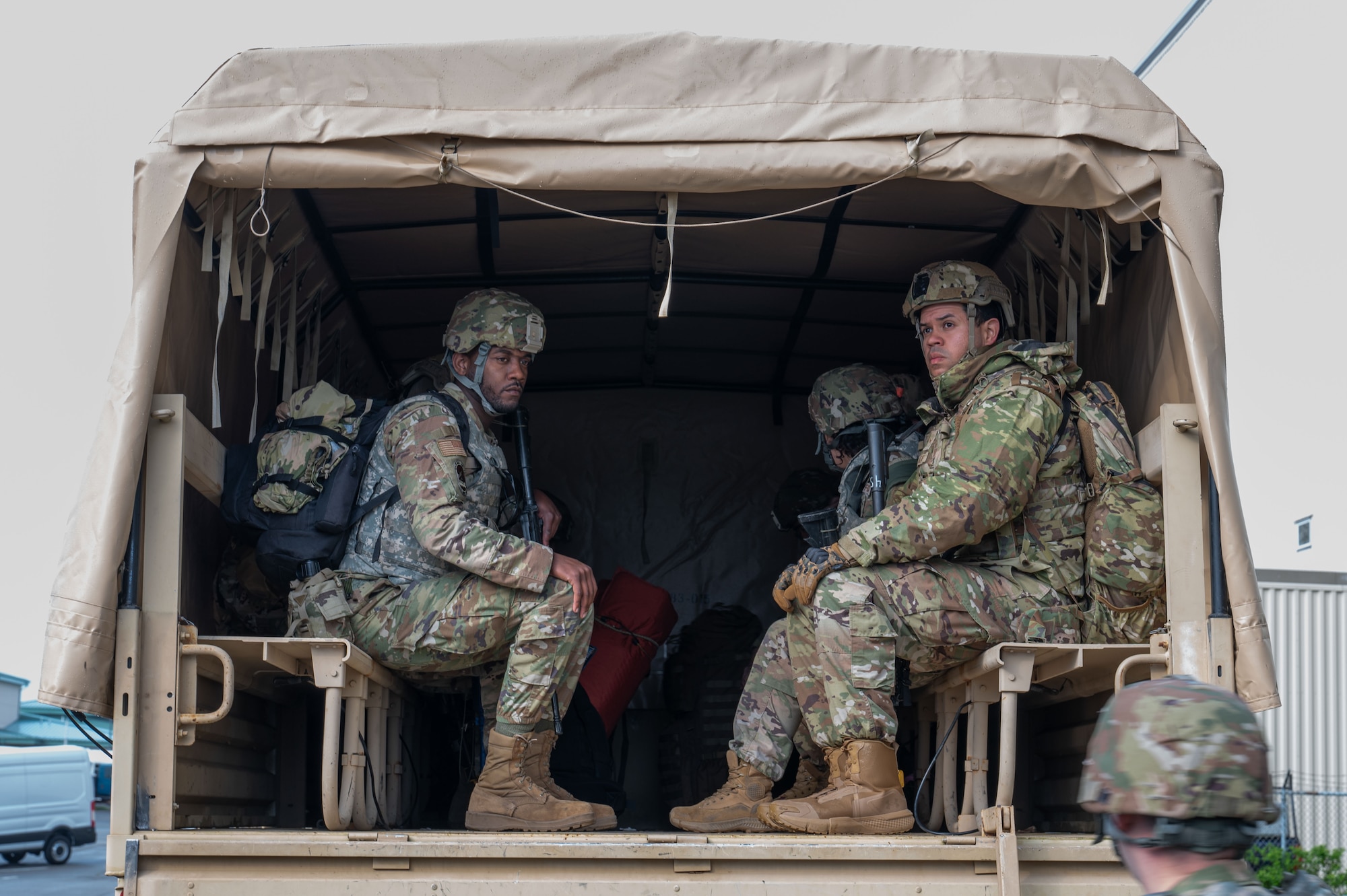 Airmen sit in a tactical vehicle.