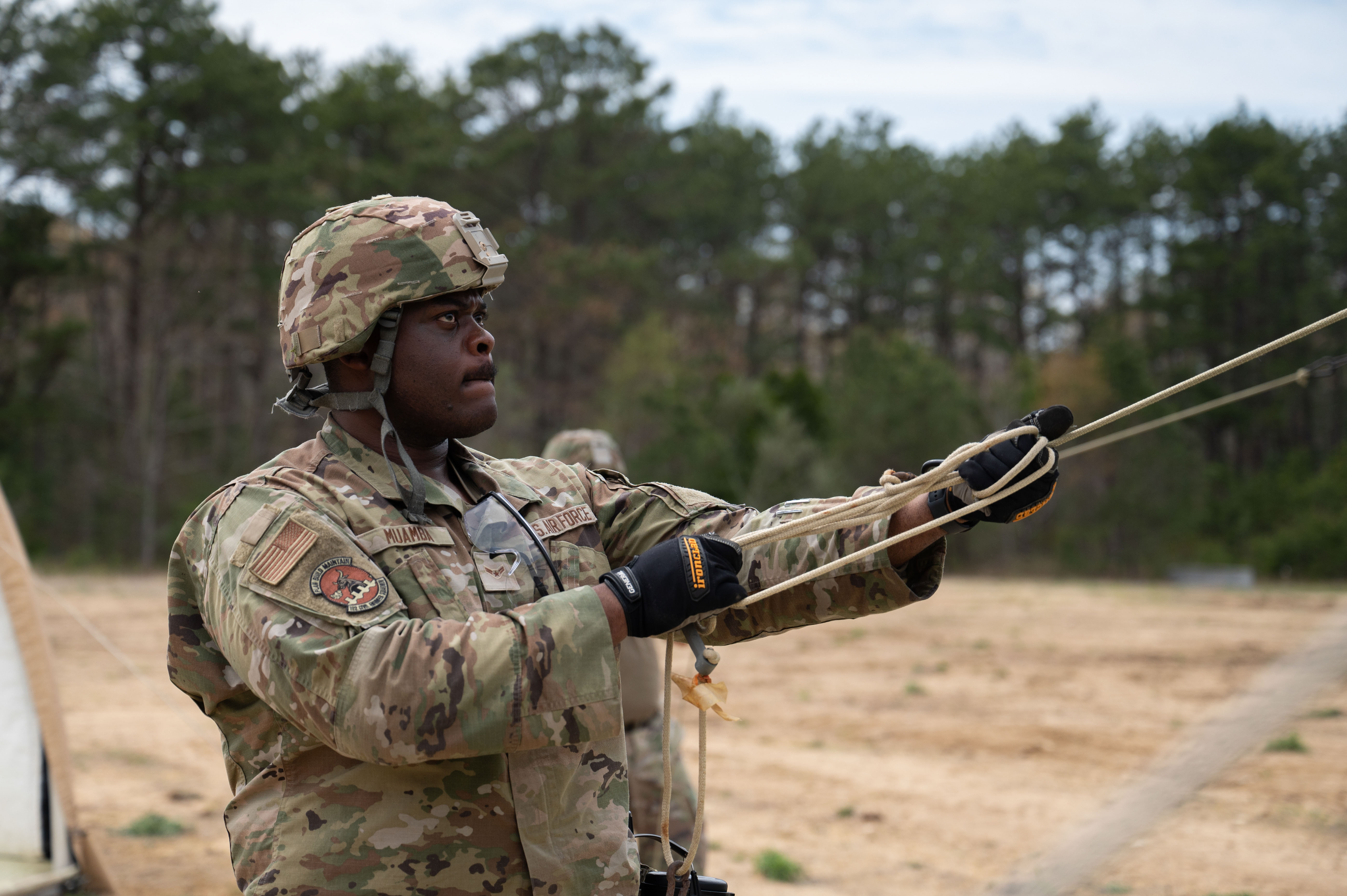 U.S. Air Force Ken Muamba, an electrical power production specialist with the 102nd Civil Engineer Squadron (CES), builds a tent on Otis Air National Guard Base, Massachusetts, May 2, 2025. In part of Exercise Iron Nomad, members of the 102nd CES trained to establish and sustain mission-ready environments at undeveloped locations, building and repairing essential infrastructure as the first in and last out of deployed operations. (Air National Guard photo by Senior Airman Julia Ahaesy)