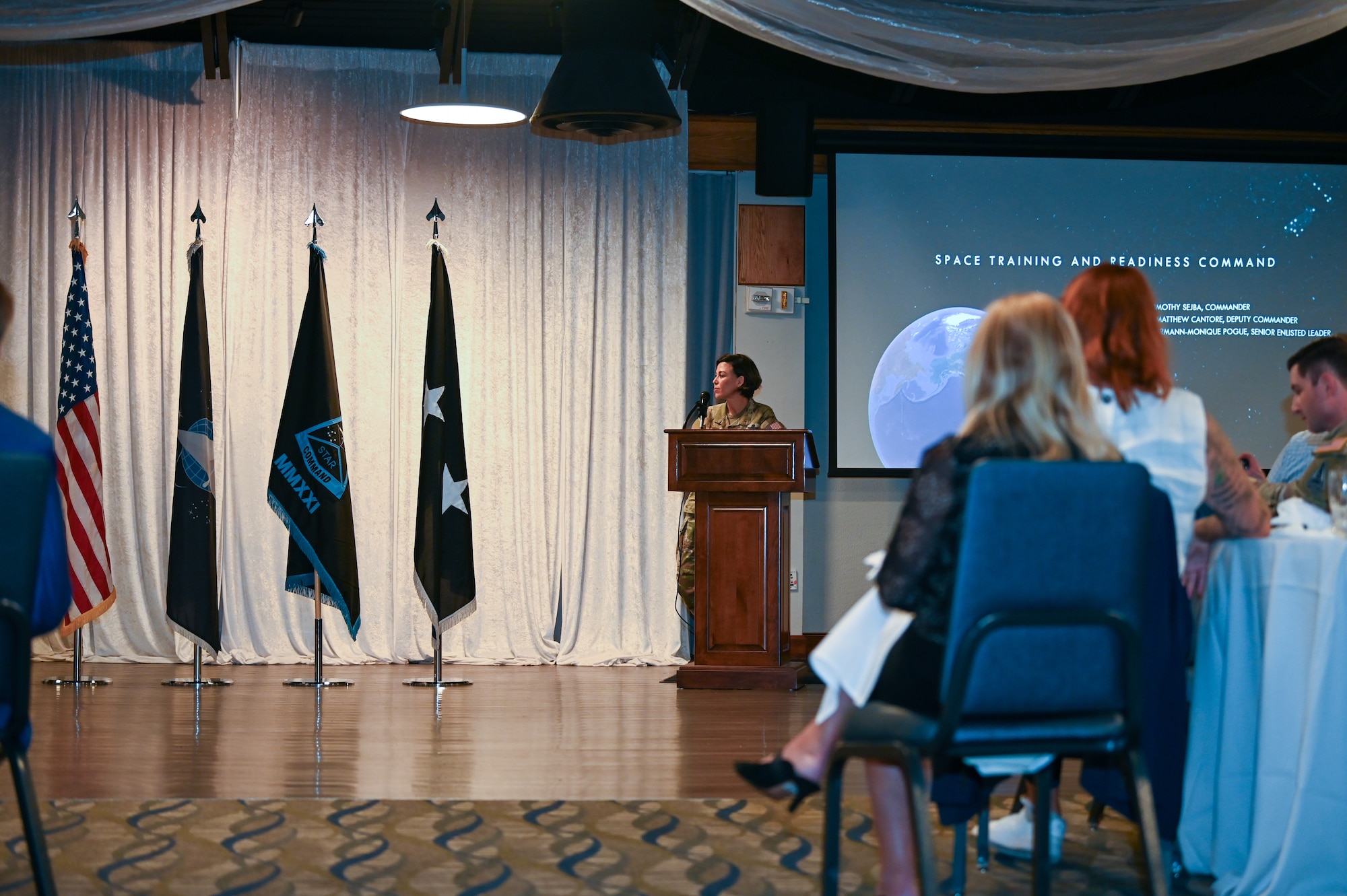 Chief Pogue standing at the podium in a room with people