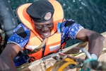 A Gambian Navy Sailor boards a merchant training vessel during a Senegalese led Visit, Board, Search, and Seizure (VBSS) training exercise at Obangame Express. Obangame Express is one of three regional maritime exercises led by U.S. Sixth Fleet as part of a comprehensive strategy to provide collaborative opportunities to African forces and international partners to address maritime security concerns. (U.S. Navy photo by Chief Mass Communication Specialist John Pearl)
