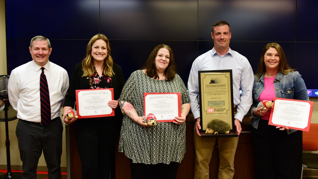 Craig Carrington (Left), U.S. Army Corps of Engineers Nashville District deputy for Project Management, presents the Hedgehog Award Trophy to Josh Frost, Regulatory Division chief, and certificates May 14, 2025, to (Left to Right) Cara Beverly, Vessica Ragon, and Mary Ann Brannan. The award recognizes the Regulatory Division Hurricane Helene Rapid Response Permitting Team for outstanding dedication and professionalism in processing more than 200 emergency permit applications following Hurricane Helene. Thomas Giordano, Aric Payne, Marian Rubin, Dani Walker, Eric Sinclair and Michael Bowling were not present but were also recognized. (USACE Photo by Lee Roberts)