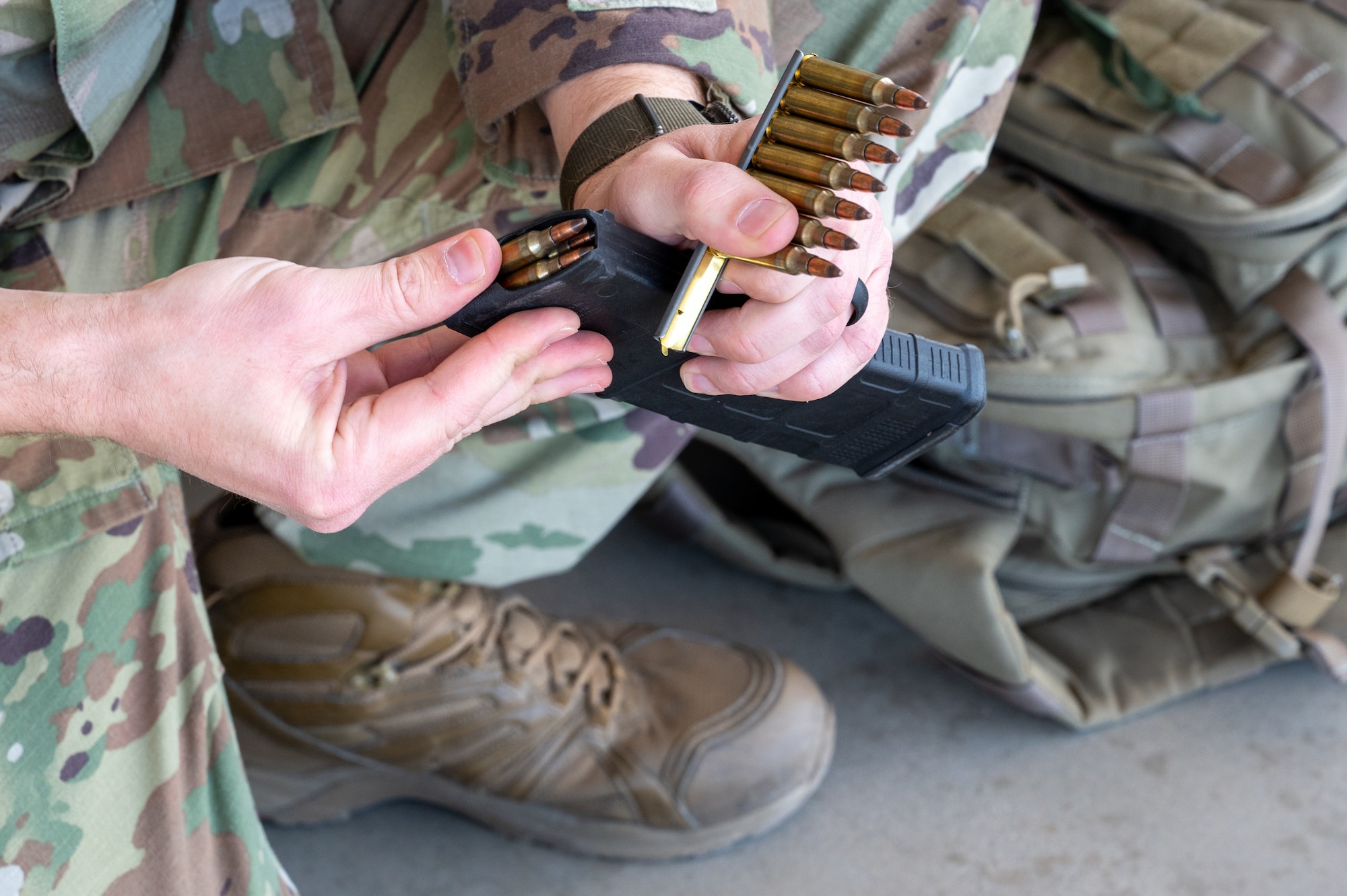 An Airman loads a magazine of an M4 carbine rifle