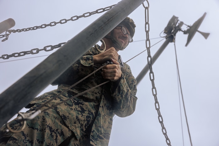 U.S. Marine Corps Lance Cpl. David Hodgkins tightens a rope to set up a Long-Range Radio System during Exercise Triad Thunder as part of Kaiju Rain on Camp Hansen, Okinawa, Japan, May 5, 2025.