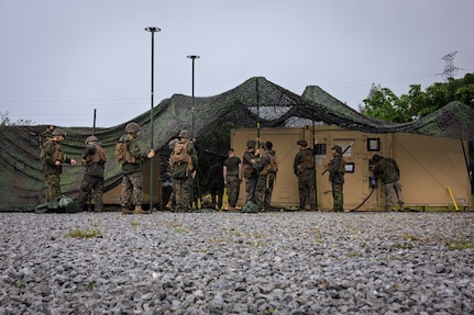 U.S. Marines with Service Company, 7th Communication Battalion, III Marine Expeditionary Force Information Group, lift Cammie netting during Exercise Triad Thunder as part of Kaiju Rain on Camp Hansen, Okinawa, Japan, May 5, 202