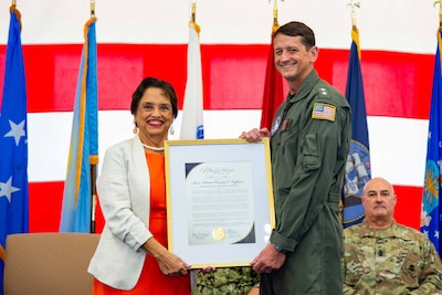Guam Gov. Lou Leon Guerrero presents the Maga'haga award to U.S. Navy Rear Adm. Greg Huffman, outgoing commander, Joint Task Force - Micronesia, during a change of command ceremony at Marine Corps Base Camp Blaz Fitness Center, May 15.